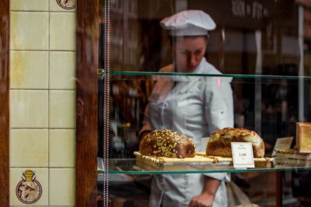 boulangère qui regarde ses pains et brioches dans sa boutique