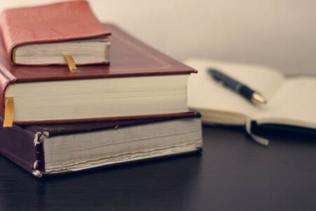 livres posé sur la table avec un livre ouvert et un crayon