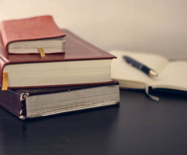 livres posé sur la table avec un livre ouvert et un crayon